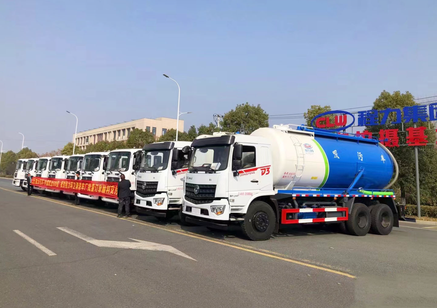 Blue and white suction trucks with customer delivery banner